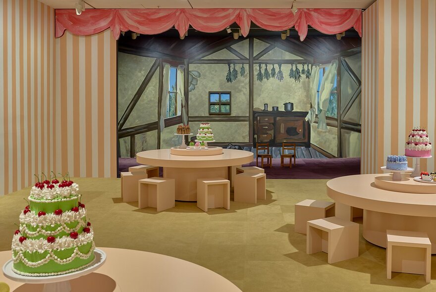Tables with model cakes in an art gallery.