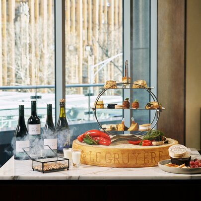 Cheese and wine display on a table near a window.