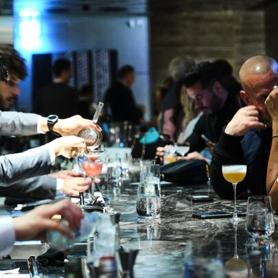 The slick-looking bartop at Society, with bartenders building drinks on one side and patrons on the other.