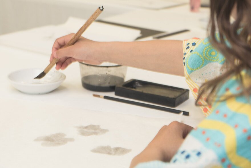A person learning the art of Japanese water colour painting.