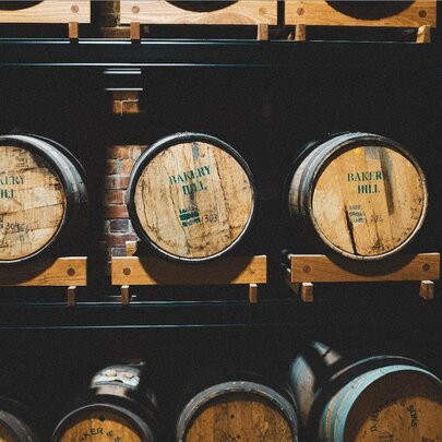 Oak barrels resting on shelves in a cellar.