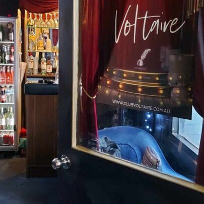 Fridges surrounding a picture of a theatre on a door.