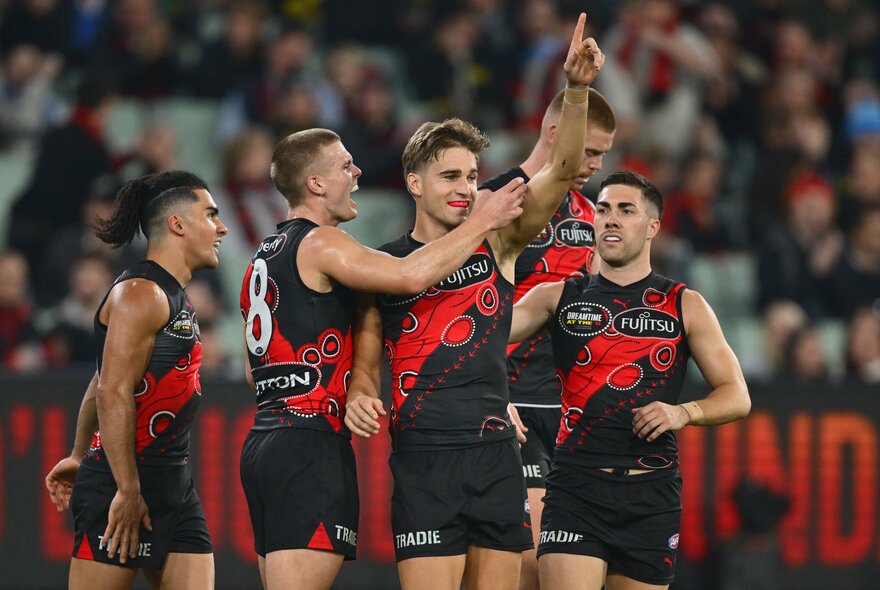 Essendon AFL football players on the field during a match.