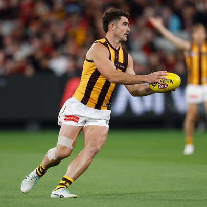 A Hawthorn football player about to pass the ball during a match. 