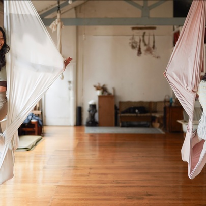 Children swinging on fabric suspension ropes in a studio setting.