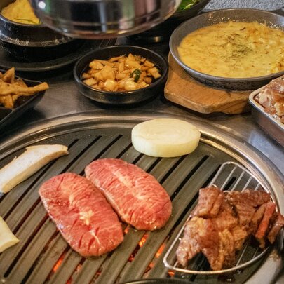 A Korean barbecue dining experience, typically featuring a variety of meats grilled directly at the table alongside various side dishes.