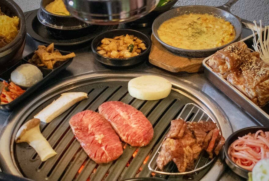 A Korean barbecue dining experience, typically featuring a variety of meats grilled directly at the table alongside various side dishes.