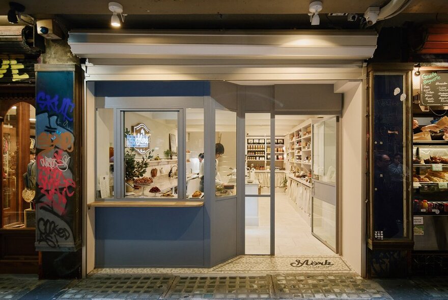 A brightly lit laneway cafe with white interiors. 