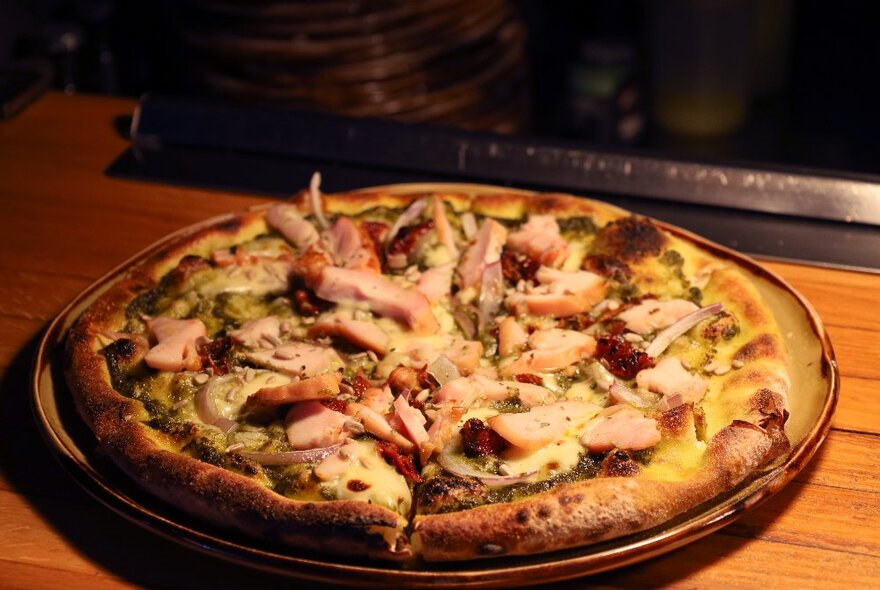 A cooked pizza on a metal tray.
