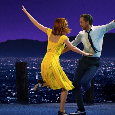 A still depicting a scene from the musical La La Land, featuring the male and female leads dancing at night against a backdrop of the twinkling valley of LA behind them.