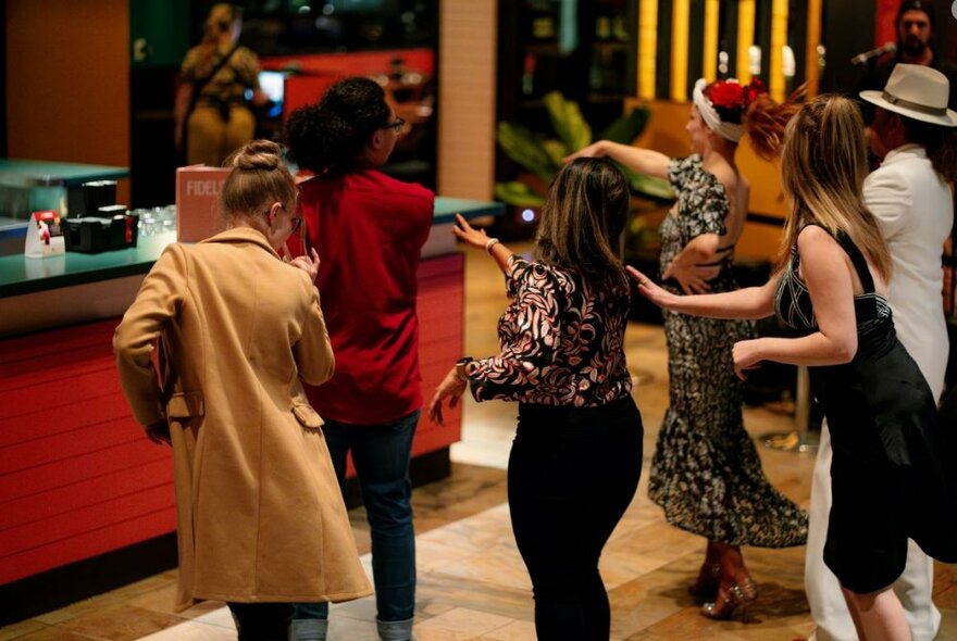 A group of people Latin dancing in a restaurant space.