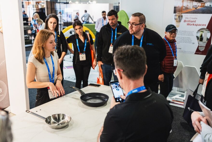 People at a kitchen and bath design expo exploring a range of cooking pans.