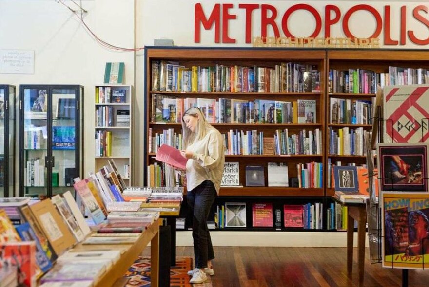 A woman reading a book in a bookstore