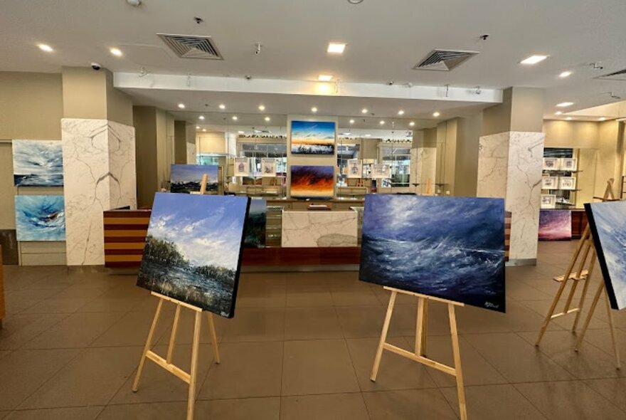 Gallery space with artworks on easels.