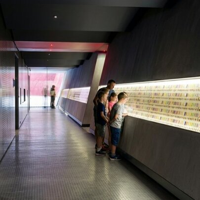Children looking at walls of illuminated medals.