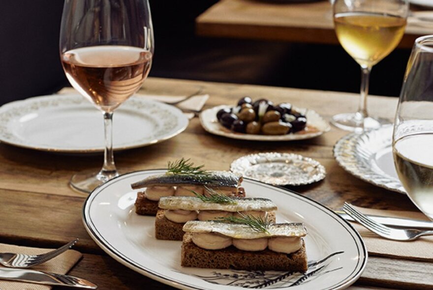 A table setting with glasses of wine and hors d'oeuvres.