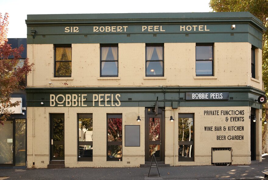 The street frontage of the Bobbie Peels pub, with cream walls and green accents.