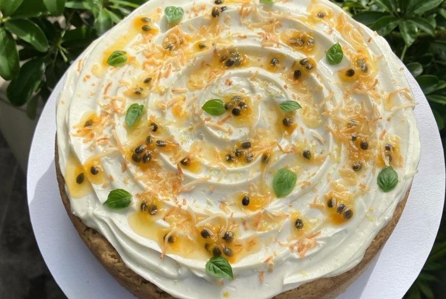 A vegan cake decorated with icing and passionfruit pulp.