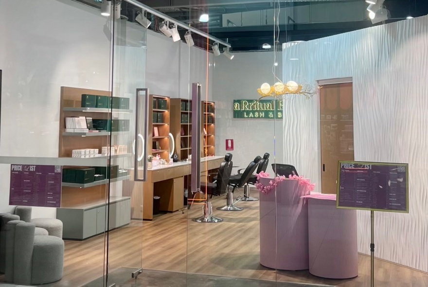 Beauty shop interior with shelves of products, mirrors and seating.