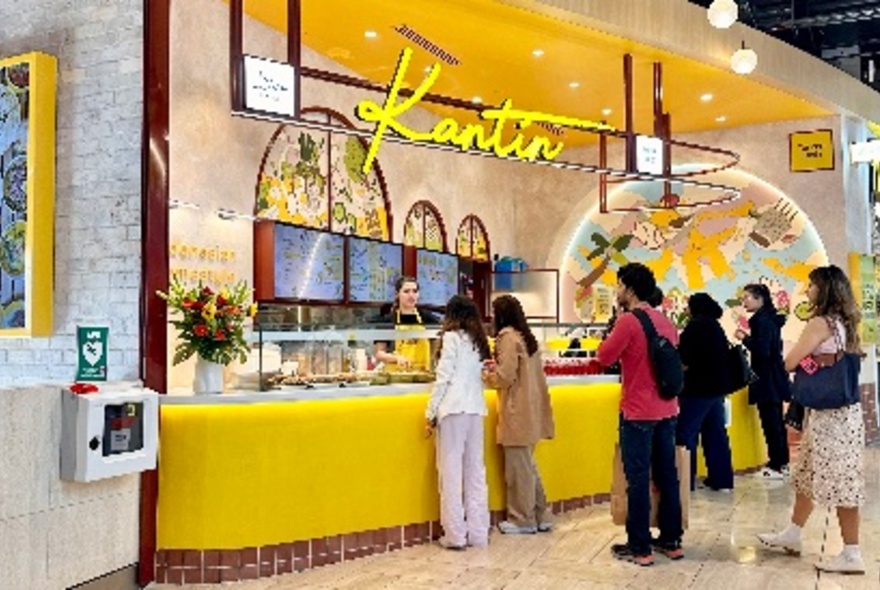 People queuing at the bright yellow counter of Kantin Emporium.