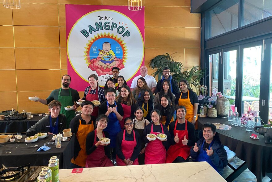 Group of peoeple holding bowls of food during a Thai cooking workshop.
