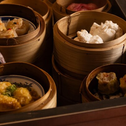 A food trolley of yum cha in small bamboo steamers.