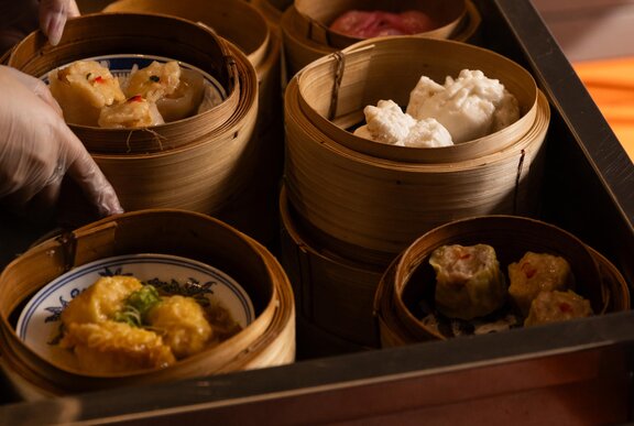 A food trolley of yum cha in small bamboo steamers.