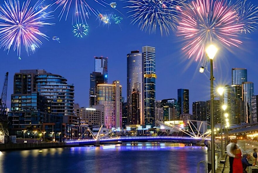The Melbourne skyline with fireworks going off in the night sky.