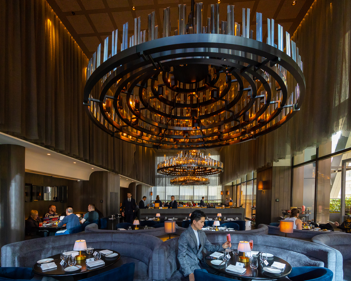 A fancy restaurant with booths and a grand chandelier.