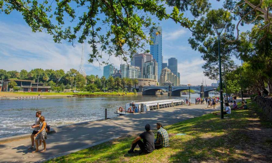 People sitting on the banks of a river in the city