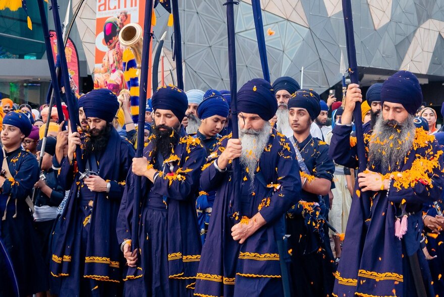 A Sikh festival in Federation Square with people in traditional blue costumes.