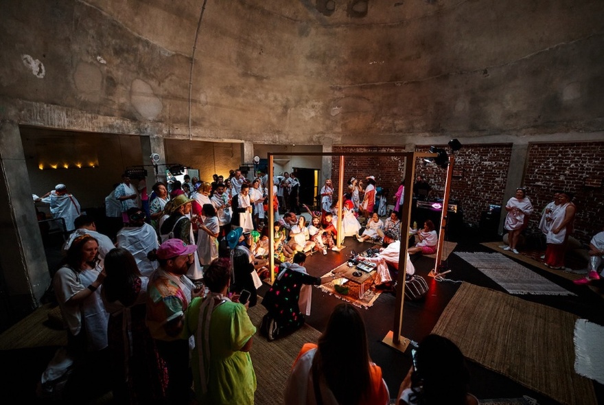 People gathered in a circle tomb-like, dark room.