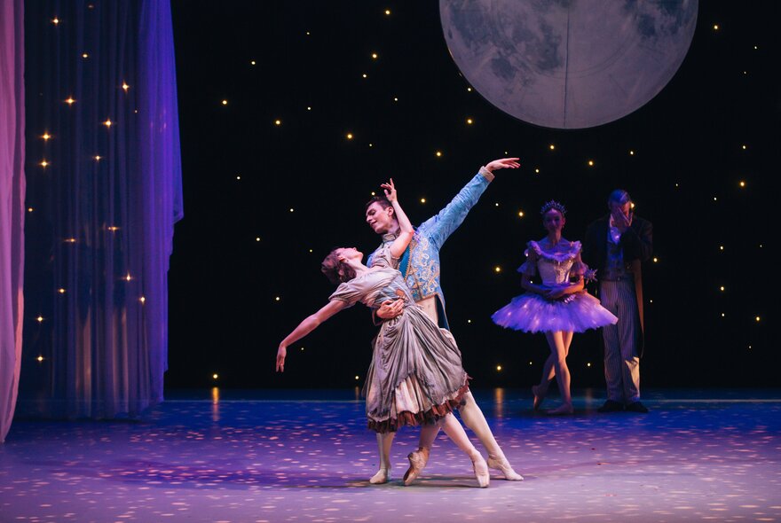 Two ballet dancers on stage dressed as Cinderella and Prince Charming.