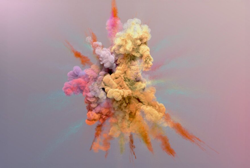 A cloud explosion of brightly coloured powders against a pale background. 