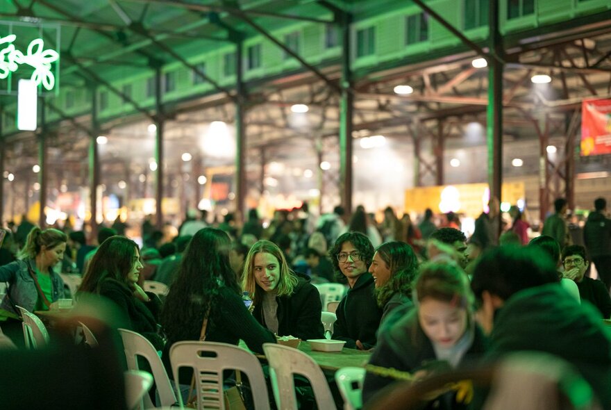 Diners at temporary tables in Shed D at the Queen Victoria Market - transformed into a hawker-style night market.