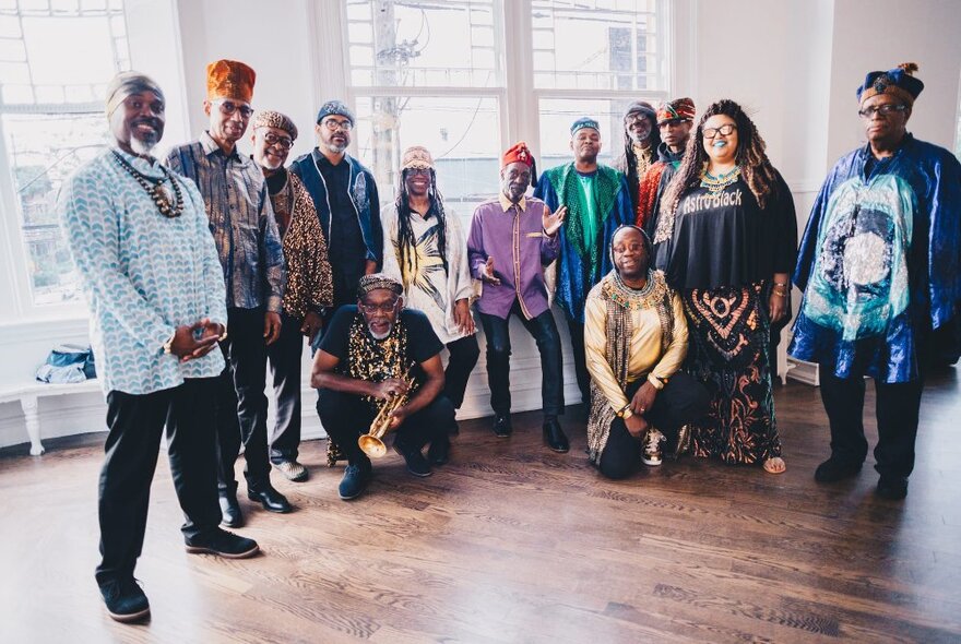 The Sun Ra Arkestra, a large ensemble of musicians, in front of large windows.