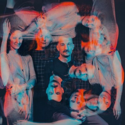 A colour filtered  image of people that is overlayed with repeat of the image at right angles. 