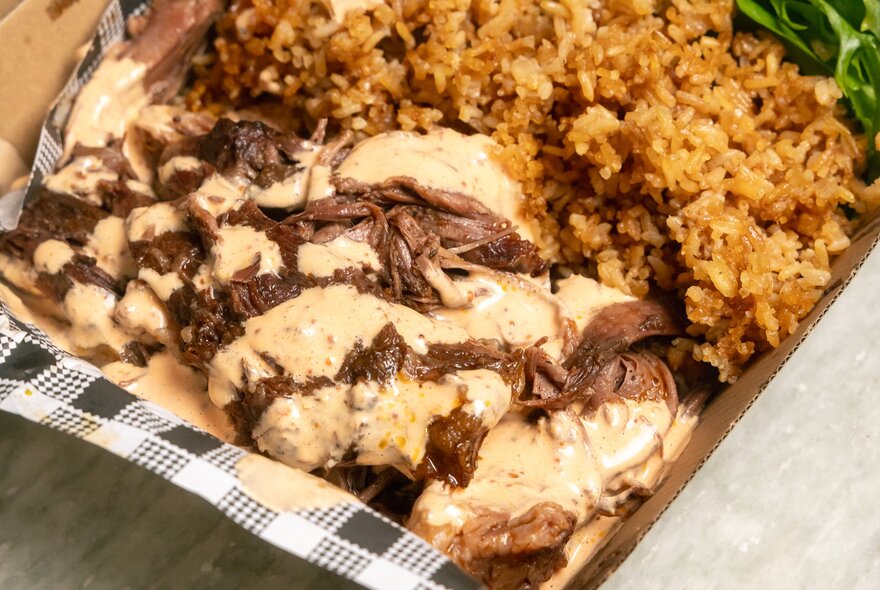 Takeaway tray of meat and rice.