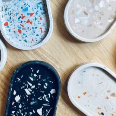 Six oval shaped terrazzo trinket trays made from resin in different colours.