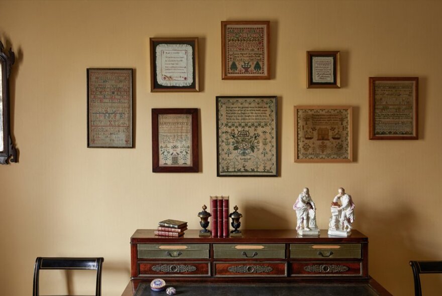 A room at The Johnson Collection Georgian mansion with objects d'art arranged on a elaborate sideboard and framed tapestries hanging on the wall. 