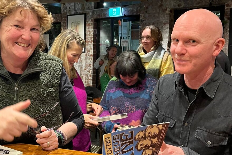 People smiling at a book signing. 