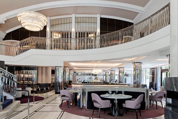 A glamorous looking bar with a mezzanine level and grand staircase.