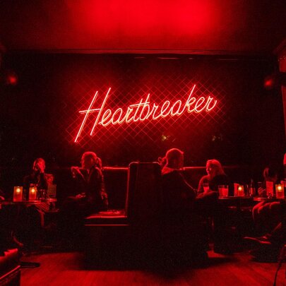 Interior of restaurant with a neon sign saying heartbreaker.