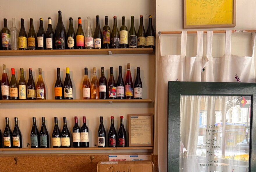 Shelves of a bright bar with an assortment of bottles. 
