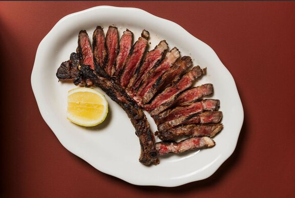 Slices of meat on a plate with lemon.