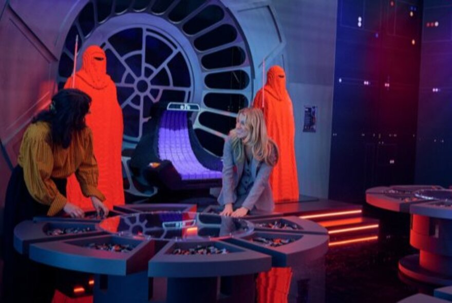 Two people looking at a display as part of the LEGO Star Wars exhibition at Melbourne Museum.