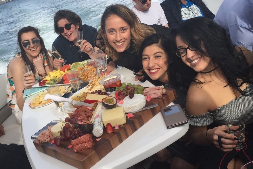 People posing for photo, with large food platter in front of them.