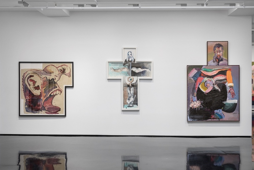 A selection of Ben Quilty's paintings from his exhibition, Trinkets, displayed on a white gallery wall and reflected on the shiny black floor.