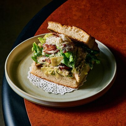 Panii with fried chicken and salad filling, on a plate on a round table.