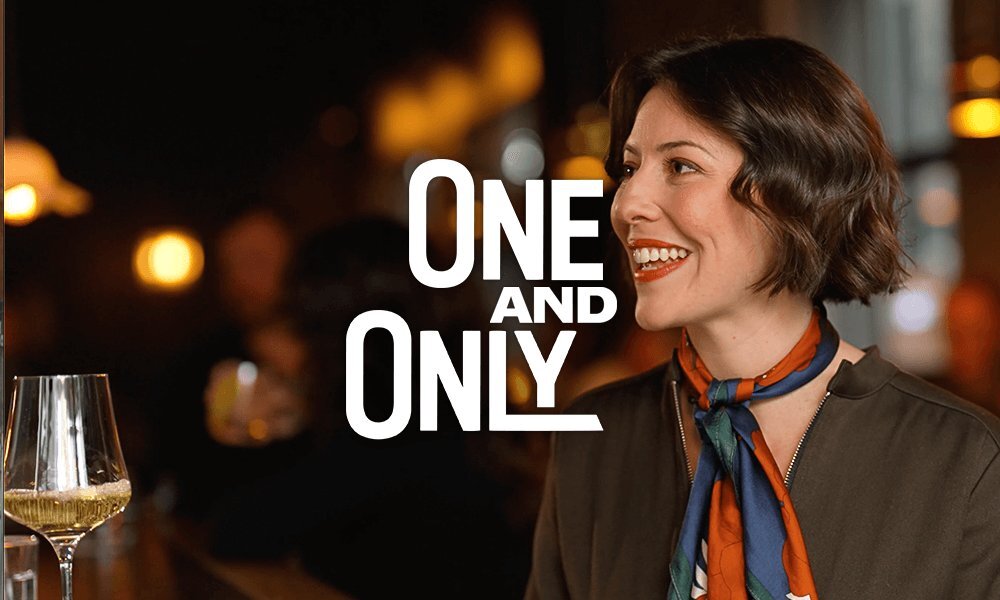 Sofia Levin sitting next to a glass of wine with the text "One and Only" over the photo. 